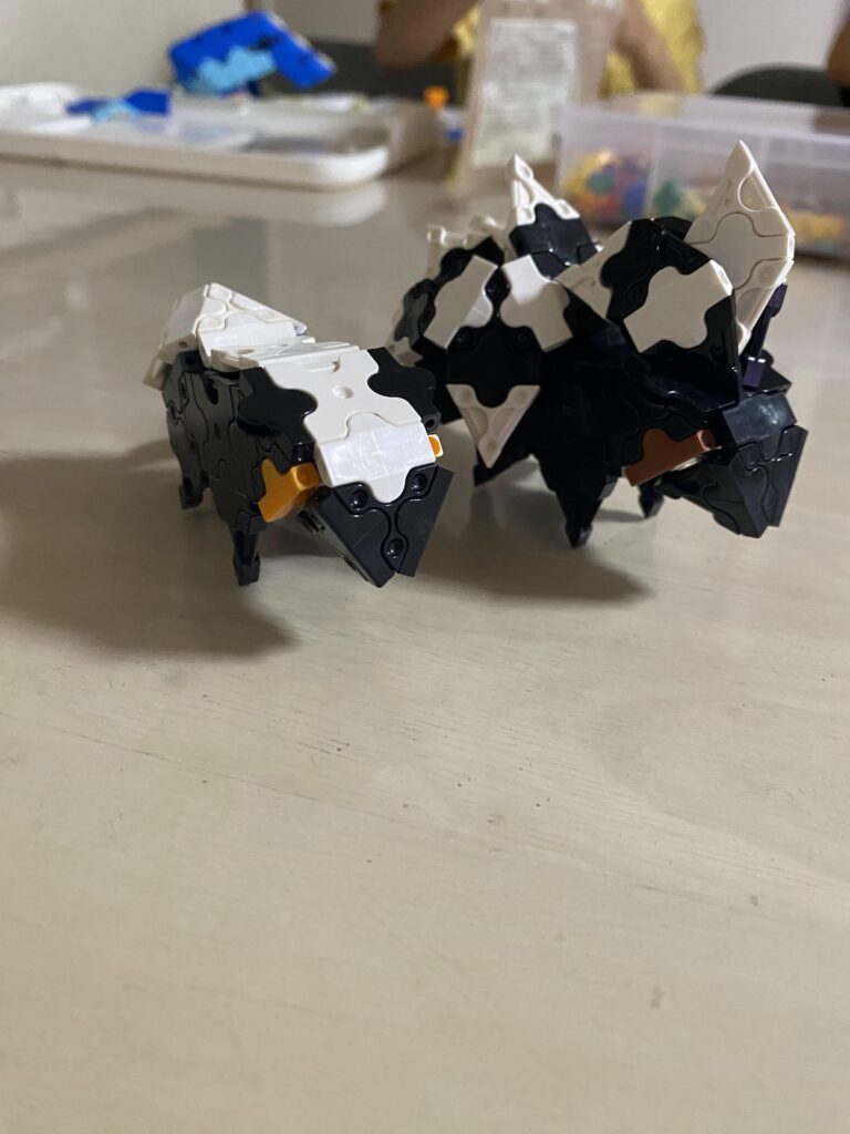 5歳の子どもがLaQで作った動物作品と一緒に笑顔で写る様子