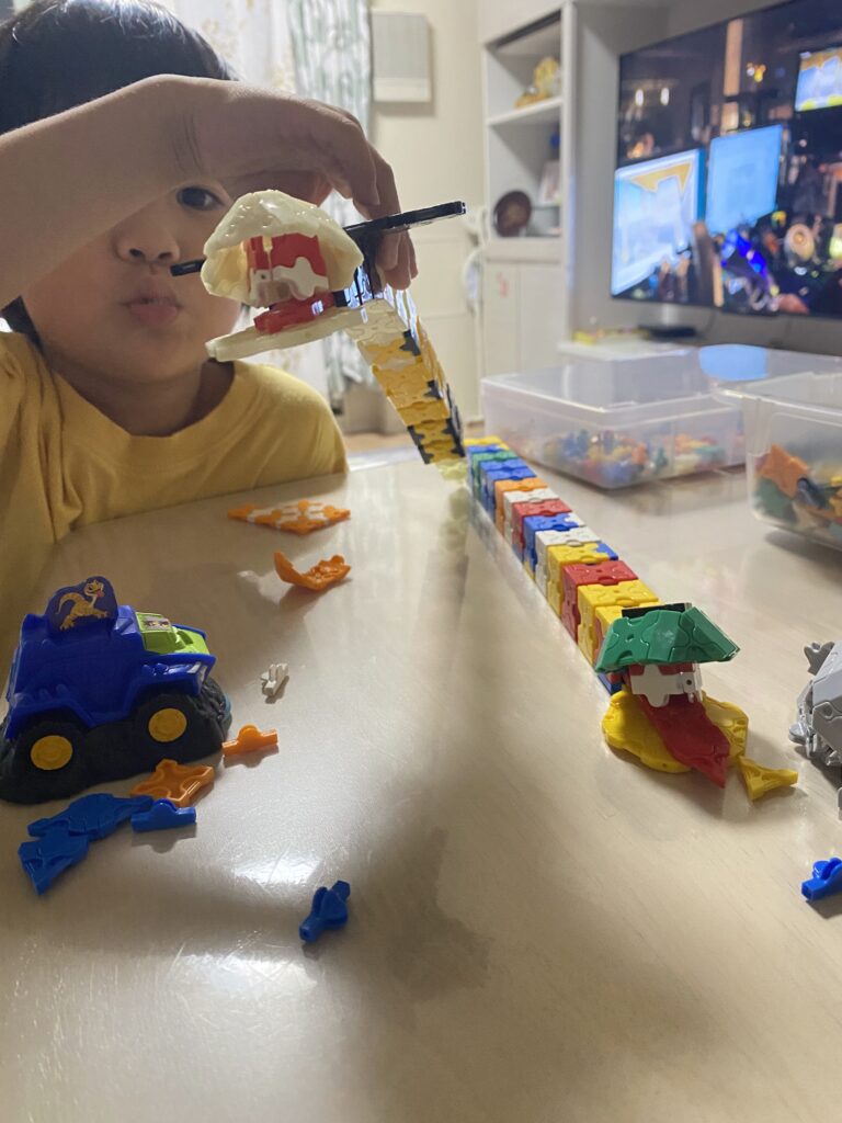 5歳の子どもがLaQで作った動物作品と一緒に笑顔で写る様子