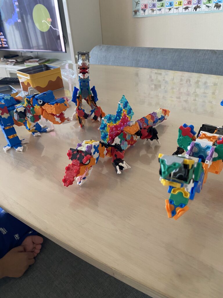 5歳の子どもがLaQで作った動物作品と一緒に笑顔で写る様子