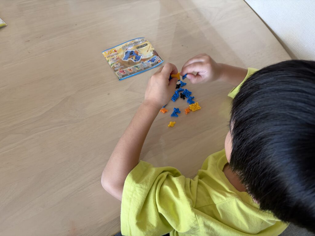 5歳の息子がLaQカプセルトイのスピノサウルスを一人で組み立てている様子